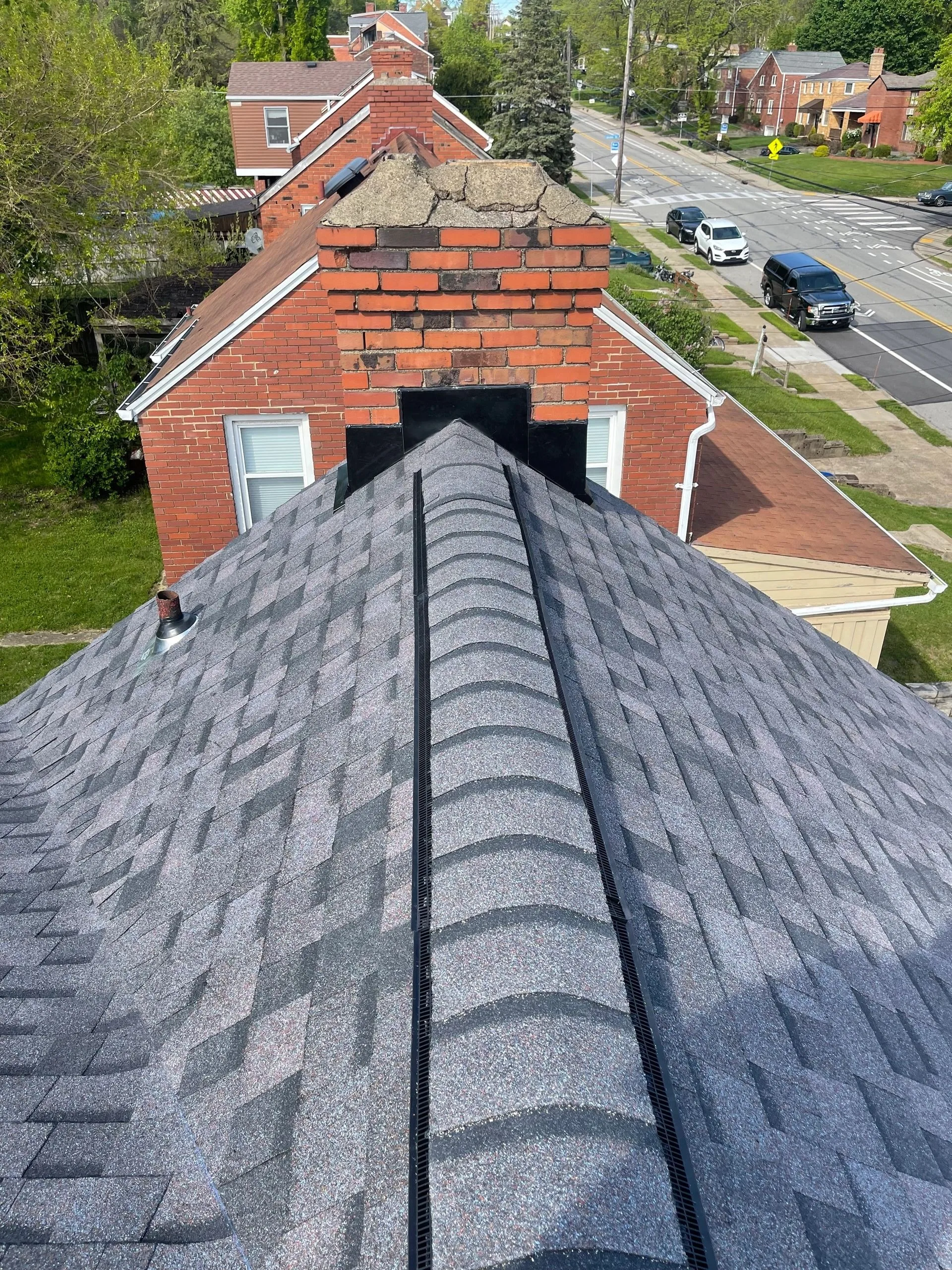 Close view of a finished ridge cap running the length of a new shingle roof