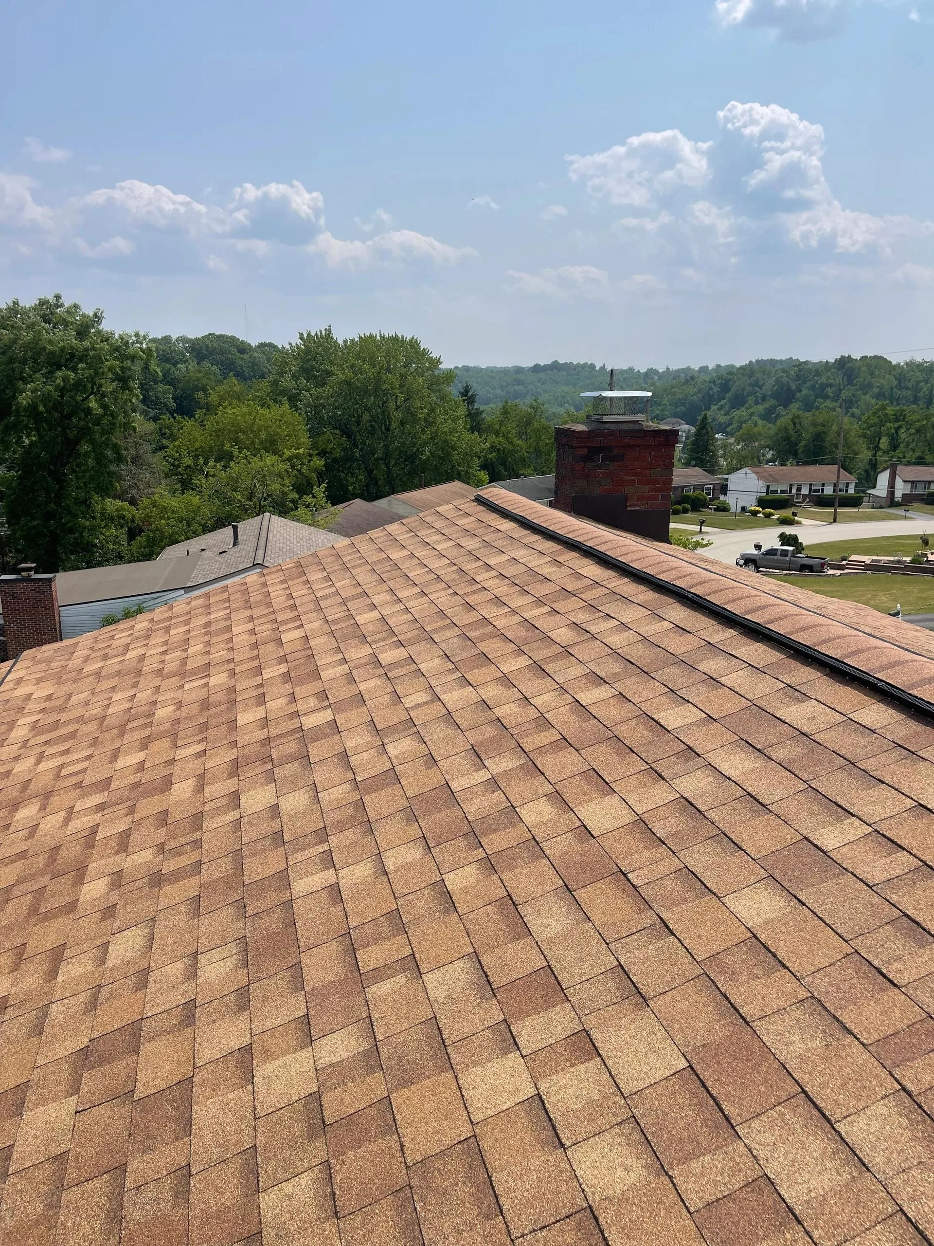 Completed weathered-wood tone shingle roof viewed along the ridge